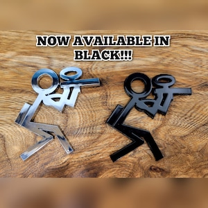 May include: Two stick figure decals, one silver and one black. The stick figures are in a sitting position with their arms raised. The text "NOW AVAILABLE IN BLACK!!!" is displayed above the decals.