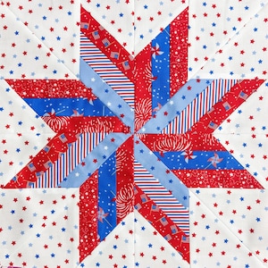 Op de afbeelding: Een patriottisch quiltblok met een sterontwerp. De ster is samengesteld uit rode, witte en blauwe stoffen met ster-, vlag- en vuurwerkpatronen. De achtergrond is wit met verspreide rode en blauwe sterren.