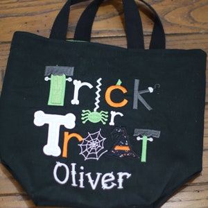 May include: Black trick or treat tote bag with embroidered Halloween themed graphics and the name Oliver.