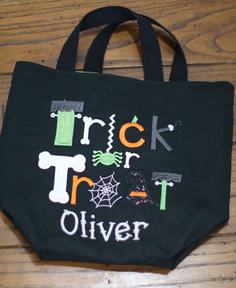 May include: Black trick or treat tote bag with embroidered Halloween themed graphics and the name Oliver.