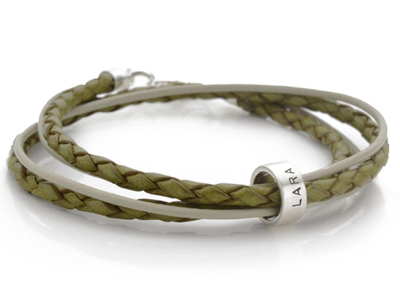 May include: A green leather bracelet with a silver bead that says "LARA" on it.