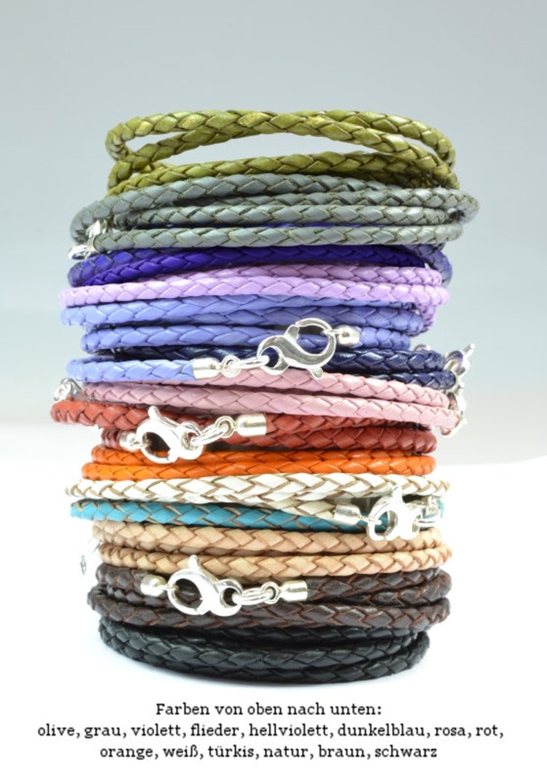 May include: A stack of 16 leather cords in various colors, including olive, gray, violet, lilac, light purple, dark blue, pink, red, orange, white, turquoise, natural, brown, and black. Each cord has a silver clasp.