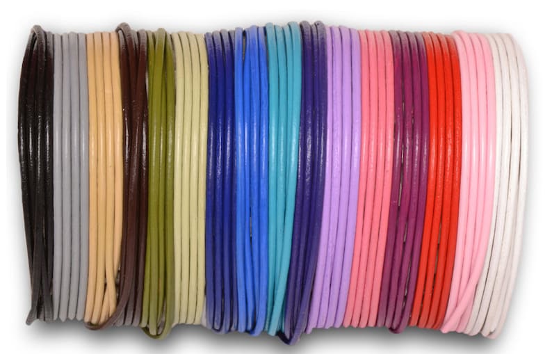 May include: Assortment of 20 leather cords in various colors, including black, brown, beige, green, blue, turquoise, purple, pink, red, and white. The cords are rolled up and arranged in a row.