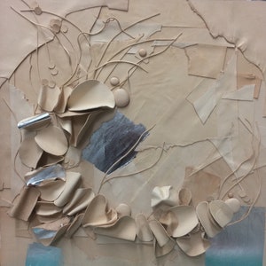 May include: Abstract mixed-media artwork with a neutral color palette. The piece features layered paper, textured elements, and metallic accents. Sculptural forms and linear details create a dynamic composition, with a touch of blue at the bottom.