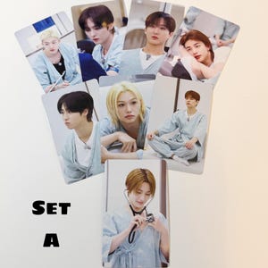 May include: A collection of seven photo cards displaying images of people in light blue hospital clothing. The cards are arranged in a fan shape, with the text "SET A" in bold black letters at the bottom. The cards are set against a white backdrop.