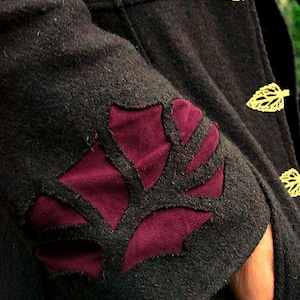 May include: A dark brown jacket with a burgundy leaf design on the sleeve. The jacket has gold leaf-shaped buttons.