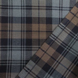May include: Close-up of a fabric with a plaid pattern in shades of brown, black, and grey.