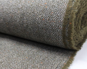May include: A close-up of a green and white fabric with a diamond pattern. The fabric has a fuzzy texture and is rolled up.