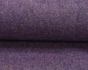 Puede incluir: Primer plano de una tela de tweed púrpura con un sutil patrón de espiga. La tela tiene un tacto suave y texturizado.