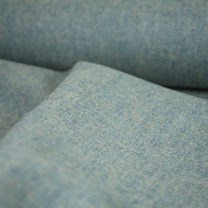 May include: Close-up of a light blue fabric with a textured surface.