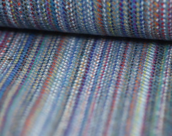 May include: Close-up of a blue and multi-colored woven fabric with a striped pattern. The fabric is soft and textured, with a variety of colors woven throughout.