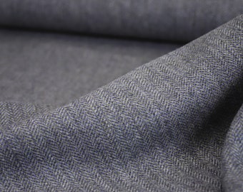 Puede incluir: Primer plano de una tela de espiga gris y azul. La tela tiene una textura sutil y un patrón tejido.