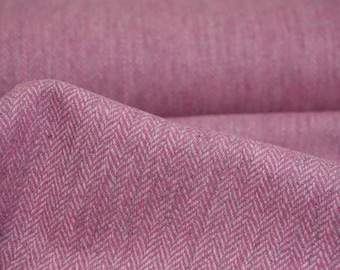 May include: Close-up of pink fabric with a herringbone pattern. The fabric is a soft pink color with a white and gray weave. The fabric is folded over, showing the texture and depth of the material. The fabric appears to be a medium weight, suitable for clothing or home decor.