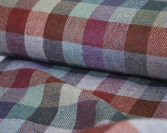 May include: A close-up of a plaid fabric with a mix of red, purple, blue, and green colors. The fabric has a soft, textured feel.
