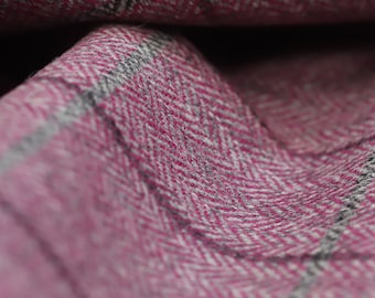 May include: Close-up of a pink and gray herringbone patterned fabric. The fabric is soft and textured, with a subtle sheen.
