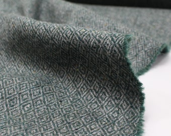 May include: Close-up of a green and white patterned fabric with a diamond-shaped design. The fabric has a soft, fuzzy texture.