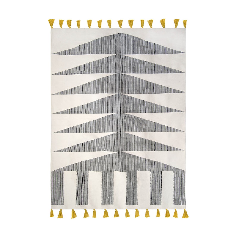 May include: A white and gray geometric patterned rug with yellow tassels. The rug has a modern design with a series of triangles and stripes.