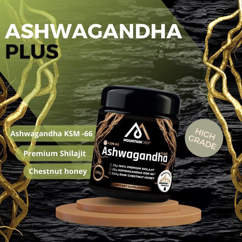 May include: A black jar with a gold label that reads "Ashwagandha Plus" and "Mountain Drop". The jar contains a dietary supplement with 25g of 100% premium shilajit, 25g of ashwagandha KSM-66, and 300g of raw chestnut honey. The jar is sitting on a wooden platform with a gold vine background.