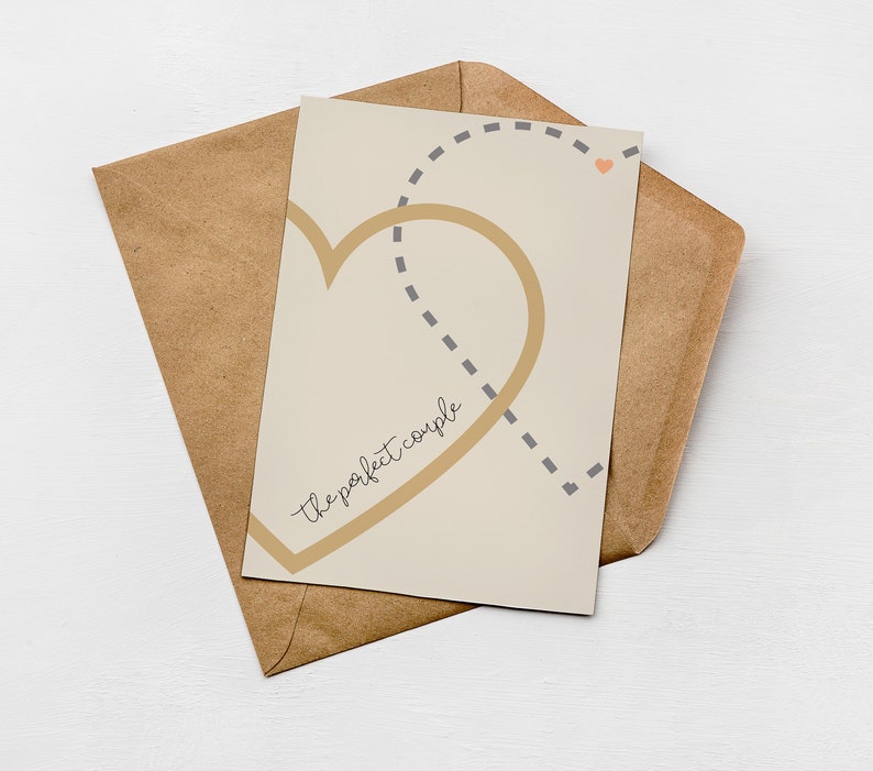 Greenwich Paper Studio, neutral minimal style love card with two interlinking hearts and 'the perfect couple' text, styled laying flat on a brown Kraft envelope.