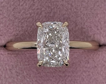 May include: A gold ring with a large, cushion-cut diamond.