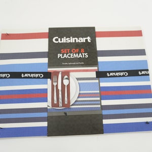 May include: A set of eight Cuisinart placemats with a striped pattern in red, white, and blue. The placemats are durable, lightweight, and flexible. The packaging includes a place setting with a fork, knife, and spoon.
