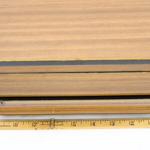 May include: A wooden box with a black and gold trim. The box is 18 inches long.