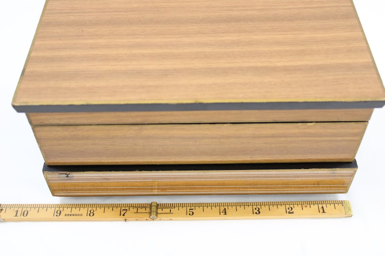 May include: A wooden box with a black and gold trim. The box is 18 inches long.