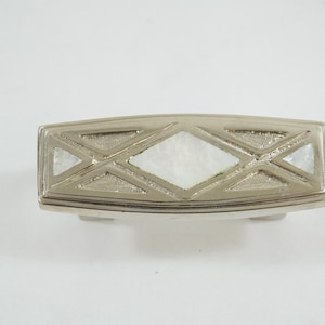 May include: Silver-toned cabinet pull with a rectangular shape. The design features a central diamond-shaped inlay and smaller diamond accents, all filled with a pearlescent material. A decorative hardware element.