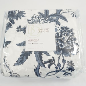 May include: A packaged duvet cover with a floral design. The cover features a white background with a pattern of blue flowers and leaves. The packaging includes a label with the text "Jardin Toile Duvet Cover" and the Ballard Designs logo.