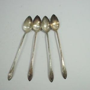 May include: Set of four silver-plated iced tea spoons. The spoons have a long, slender handle and a rounded bowl.