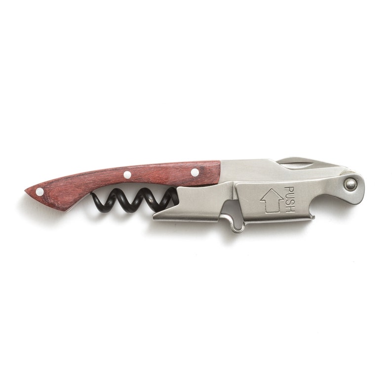 May include: A silver and wood corkscrew with a built-in bottle opener. The corkscrew has a black, spring-loaded worm and a wooden handle. The bottle opener has a "PUSH" label.