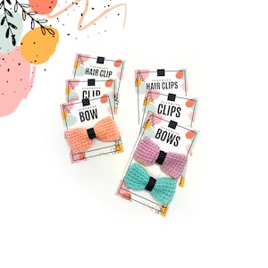 May include: Two sets of handmade crocheted bows in pink, peach, and mint green colors. The bows are displayed on cards with the text "Handmade Bows", "Handmade Clips", and "Handmade Hair Clip".