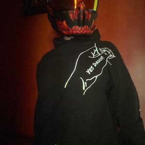May include: Black hoodie with the text "YES DADDY!" and a motorcycle graphic. The hoodie is from "CRTY'S CLOSET". The person is wearing a motorcycle helmet with a red and black design.