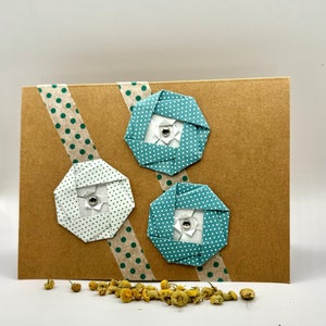 Cartão de felicitações feito à mão com flores de origami de bolinhas verdes e brancas em dois tons (em branco dentro)