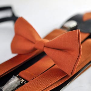 May include: A set of brown suspenders and a matching bow tie. The suspenders have adjustable clips and the bow tie is made of a soft fabric.