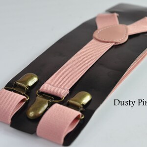 Peut inclure: Bretelles rose poussi&eacute;reux avec des clips m&eacute;talliques dor&eacute;s. Les bretelles sont faites d'un tissu doux et tiss&eacute; et ont un design classique en Y.