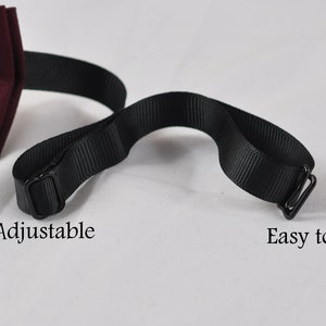 May include: A burgundy bow tie with a black adjustable strap and a metal clip. The text Adjustable is printed near the sliding buckle, and the text Easy to clip is printed near the metal hook fastener on the black fabric strap.