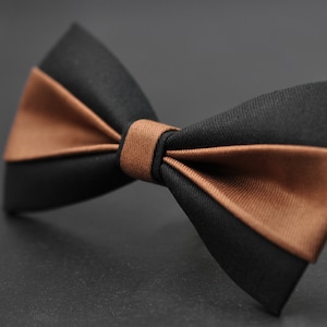 Peut inclure: Un nœud papillon marron et noir. Le nœud papillon est fait d'un tissu lisse et a un design classique.