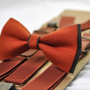 May include: A set of brown suspenders and a matching bow tie. The bow tie has a black trim.