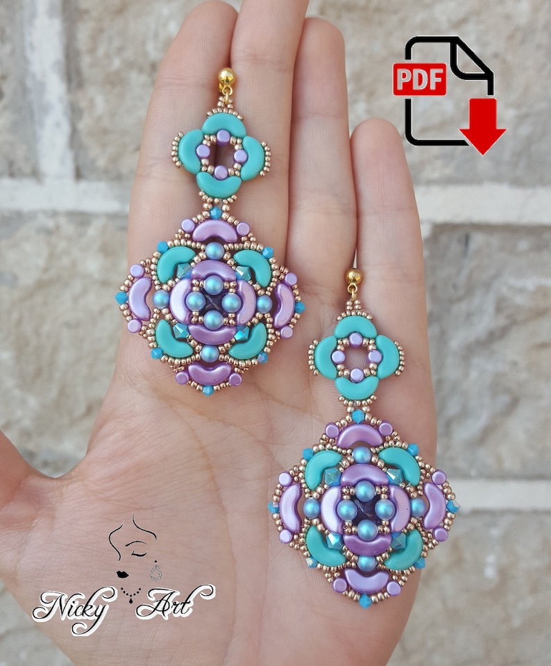 K&ouml;nnte beinhalten: Ein Paar t&uuml;rkisfarbene und violette Perlenohrringe mit goldenen Akzenten. Die Ohrringe haben die Form einer Blume mit einem kleineren Blumenanh&auml;nger, der an der Unterseite h&auml;ngt. Die Ohrringe werden in einer Hand gehalten.