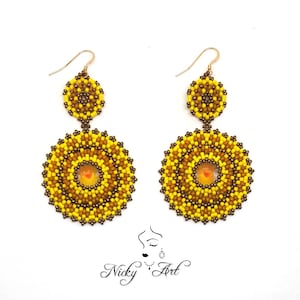 May include: A pair of yellow and brown beaded earrings with a circular design. The earrings have a smaller circle on top of a larger circle.