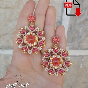 Può includere: Un paio di orecchini con perline con un design a stella rosa e bianca e un grande cristallo al centro. Gli orecchini sono appesi a un cristallo rosa.