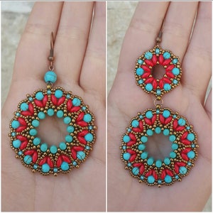May include: A pair of turquoise and red beaded earrings with a circular design. The earrings are made with small beads and have a copper wire loop for hanging.