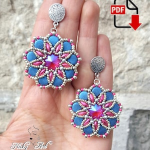 May include: A pair of blue and pink beaded earrings with a silver metal finding. The earrings are shaped like a flower with a crystal in the centre.