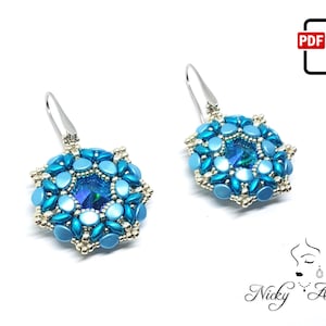 Puede incluir: Un par de pendientes de cuentas azules y plateadas con un centro de cristal. Los pendientes tienen forma de flor.