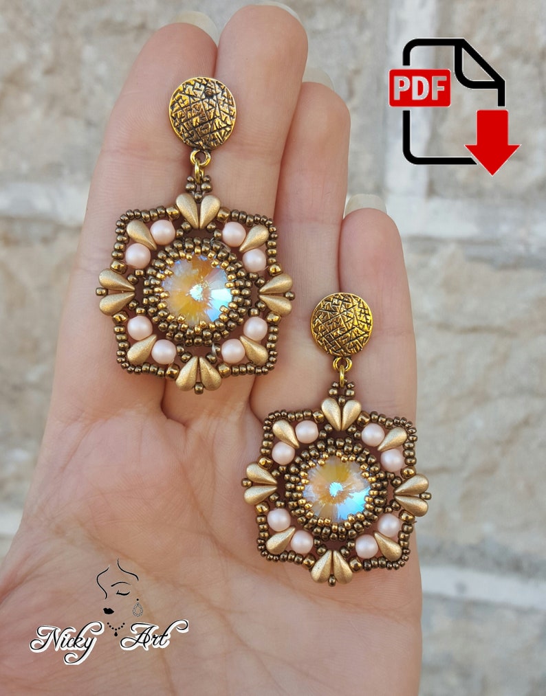 May include: A pair of gold and beige beaded earrings with a square shape and a crystal center. The earrings are hanging from a gold hook.