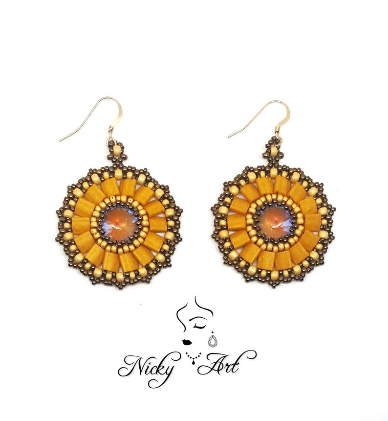 May include: A pair of gold and brown beaded earrings with a round, sun-like design. Each earring features a small, iridescent gemstone in the centre.