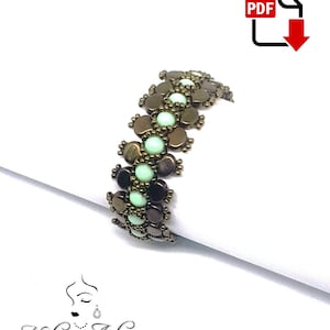 Op de afbeelding: Een armband met bruine en groene kralen in een geometrisch patroon. De armband ligt op een wit oppervlak.