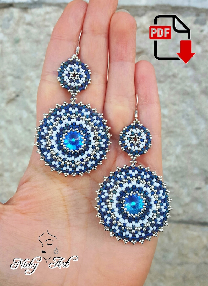 May include: A pair of blue and white beaded earrings with a crystal centre. The earrings are dangling and have a circular shape.