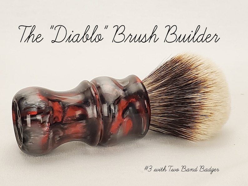 An example of an artisan made to order shaving brush in the Diablo colorway, consisting of red, silver, and black with a high density two band badger knot.